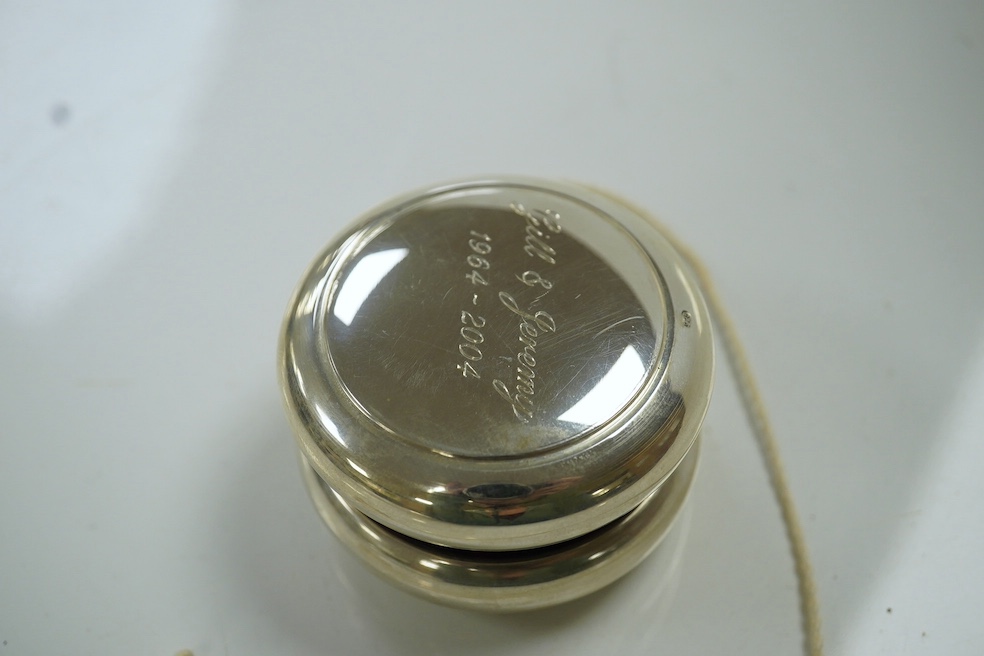 A modern silver mounted yo-yo, Practical Silverware, London, 2003, 56mm, with engraved inscription. Condition - fair to good